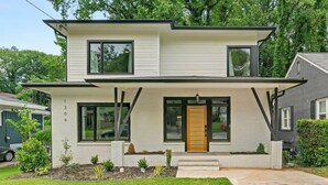 A modern two-story house with a flat roof, large windows, and a front porch. - Top Notch 2 (Atlanta)