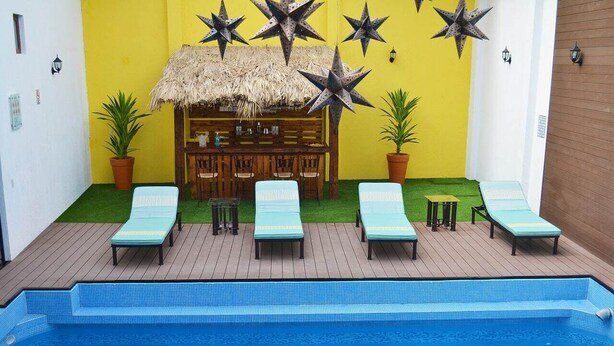 A pool area with lounge chairs, a bar, and decorative star-shaped lights. - La Casona Pirámides (San Martin de las Pirámides)