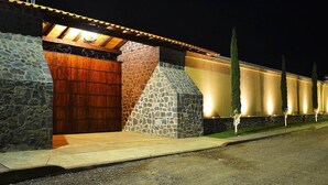 A building with a stone facade, a wooden door, and a well-lit exterior. - La Casona Pirámides (San Martin de las Pirámides)