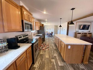 A modern kitchen with wooden cabinets, stainless steel appliances, and a central island. - 3BR Family Home | Red Rock Views+Stargazing (Kanab)