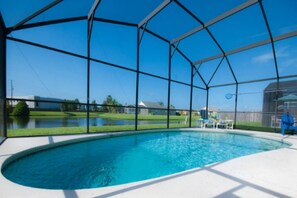 A swimming pool with a clear view of the surrounding area, including a house and a grassy field. - Lovely 3 Bedroom 2 Bath Villa (Kissimmee)