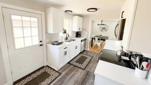 A compact kitchen with white cabinets, a black countertop, and a dining area with a white chair. - 3 Bedroom, Open Layout - Walk to Anschutz Medical! (Aurora)