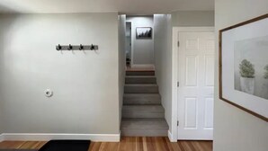 A hallway with a coat rack, a door with a framed picture, and a staircase leading to another room. - 3 Bedroom, Open Layout - Walk to Anschutz Medical! (Aurora)