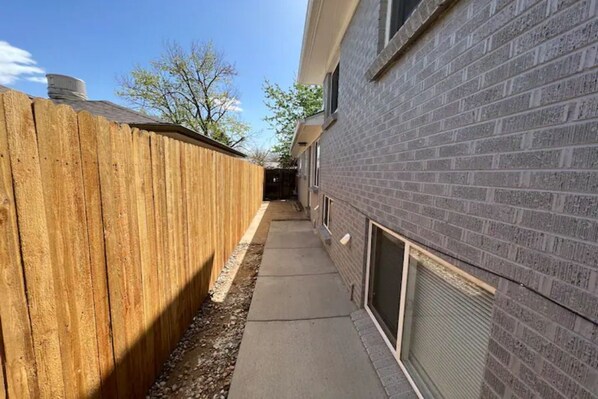 outdoor space with brick facade and wooden fence.