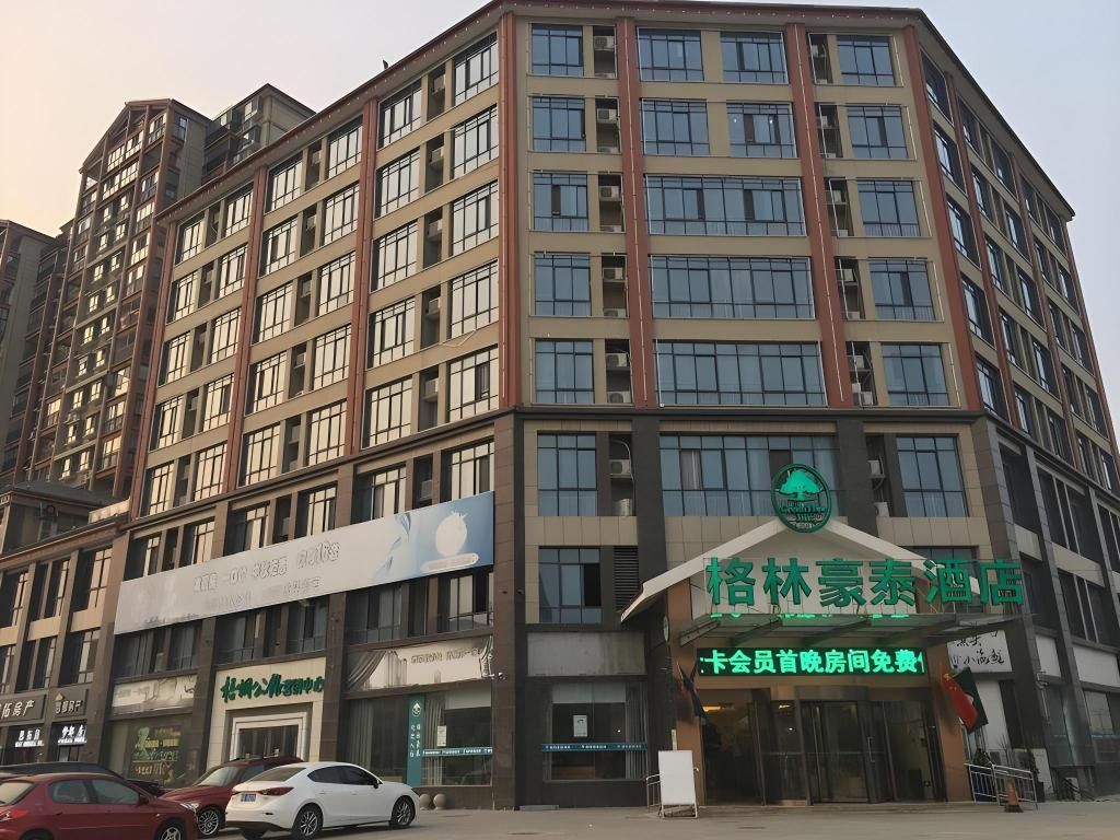 A multi-story building with a green sign indicating a hotel.