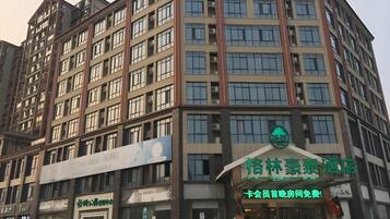 A multi-story building with a green sign indicating a hotel.