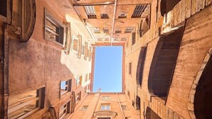 A narrow alleyway with a clear blue sky visible through a large window at the end. - Opéra 2 - Lovely studio Hôtel de Ville (Lyon)