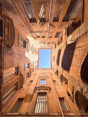 A narrow alleyway with a clear blue sky visible through a large window at the end. - Opéra 2 - Lovely studio Hôtel de Ville (Lyon)