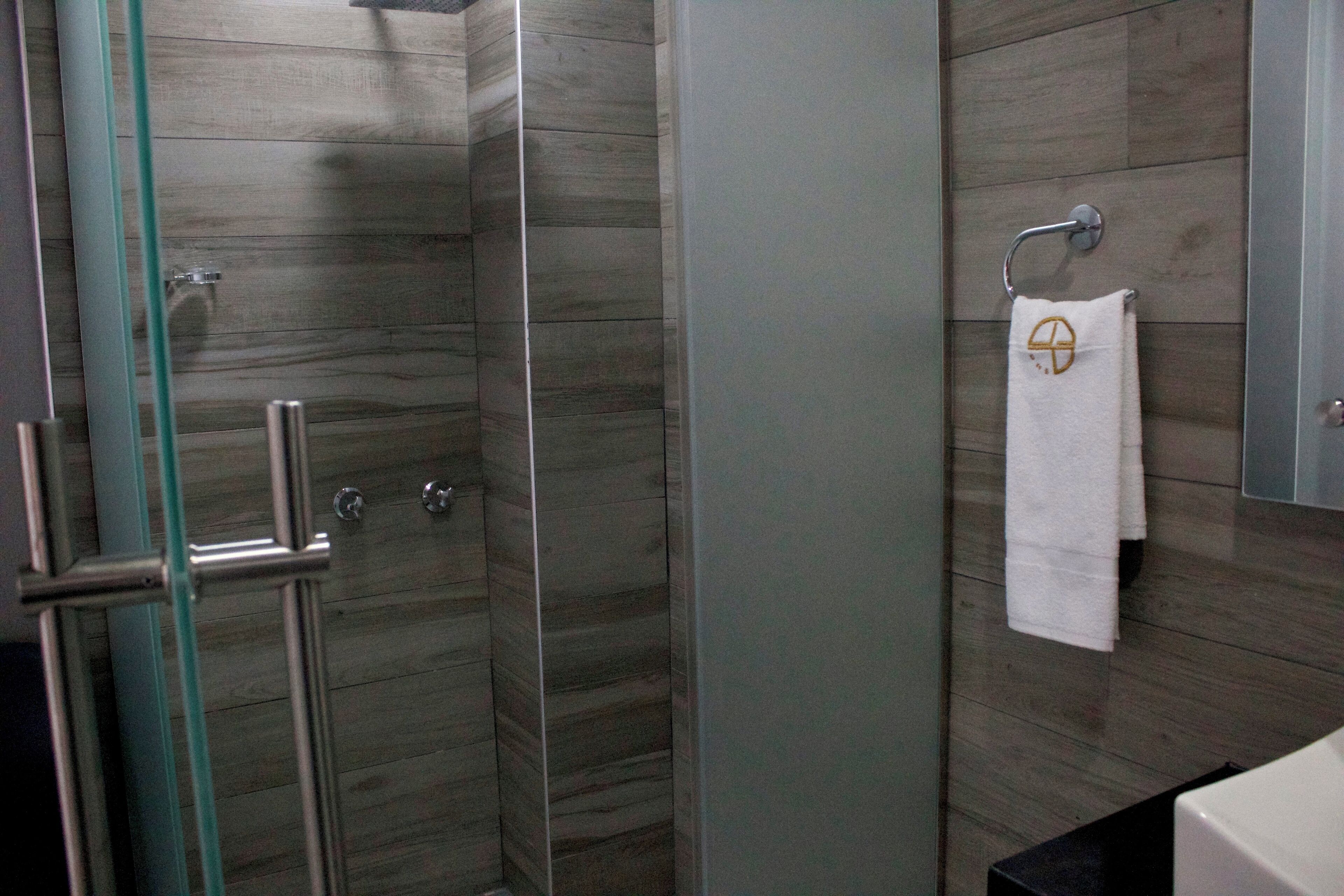 deluxe double room | bathroom | shower, rainfall showerhead, hair dryer, towels