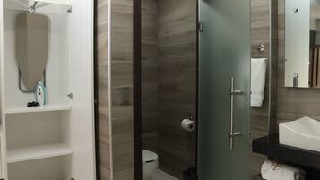 Un bagno moderno con cabina doccia in vetro, un water bianco e un mobile lavabo con specchio e lavandino.