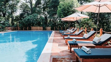 Alberca al aire libre y camastros