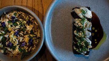 Two bowls of food on a wooden table.