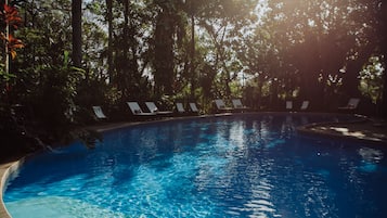 Alberca al aire libre y camastros