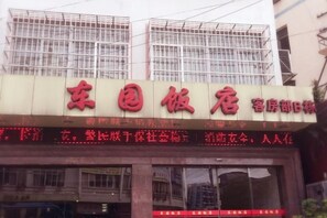 Un letrero de hotel con caracteres chinos, que indica el nombre del hotel y posiblemente sus servicios.