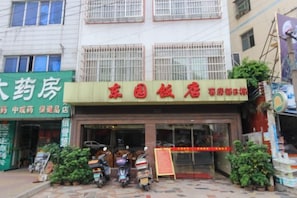 Un edificio con un letrero verde a la izquierda y uno rojo a la derecha.