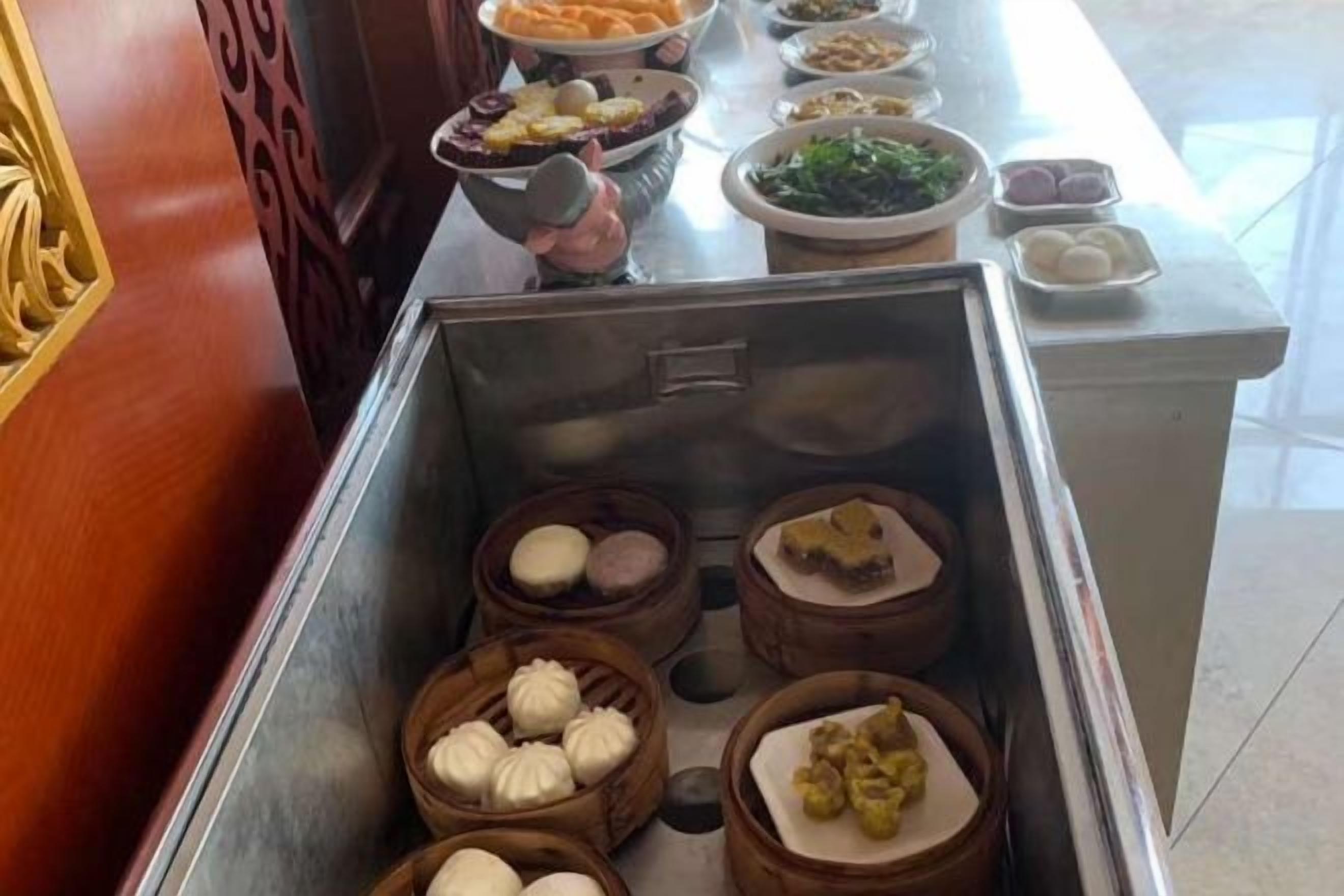 A buffet with various food items in bowls and containers.