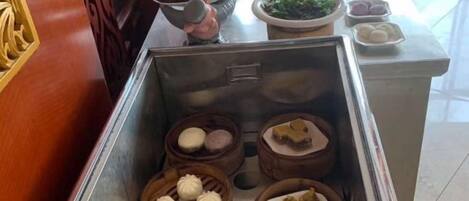 A buffet with various food items in bowls and containers.