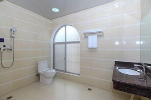 Un baño con ducha, inodoro y lavamanos.