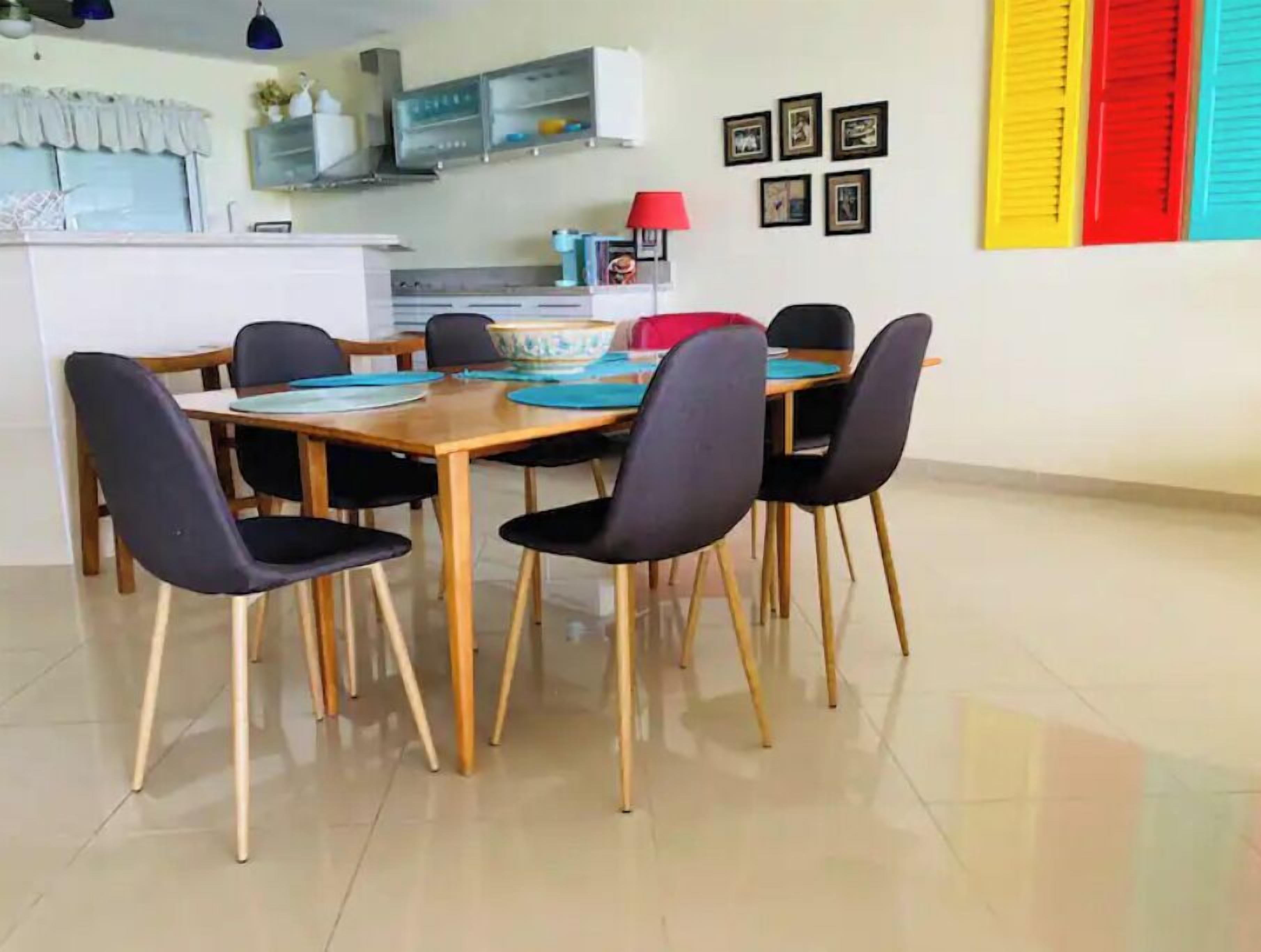 A dining area with a wooden table and black chairs.