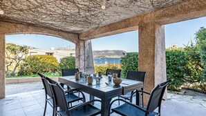 An outdoor patio with a table and chairs, a view of the sea, and a stone ceiling. - Lower villa refurbished, air conditioning and terrace with sea view (ST MANDRIER SUR MER)
