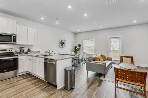 A modern kitchen with white cabinetry, a stainless steel oven, and a built-in microwave. - LUXURY TOWNHOME NEAR DOWNTOWN AND PENSACOLA BEACH (Pensacola)