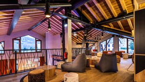 A modern interior with wooden beams, large windows, and comfortable seating areas. - Chambre Cosy! Parfait pour Travail à Distance | By LeaveTown (Bourg Saint Maurice)