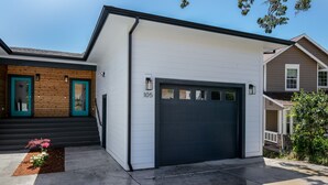 Ein modernes, zweistöckiges Haus mit Garage, Hausnummer 105 und einer Holztür.