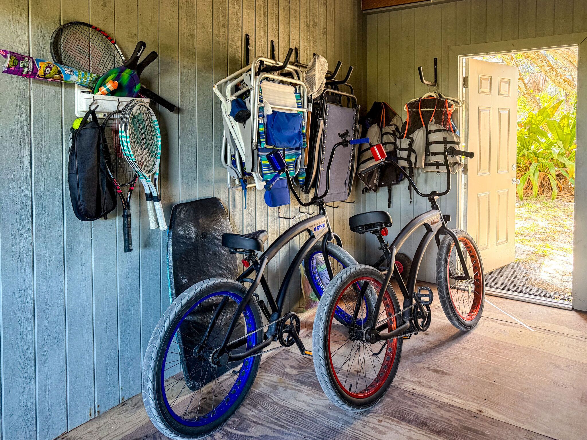 A bicycle with a basket and a child seat parked inside a room with wooden walls.