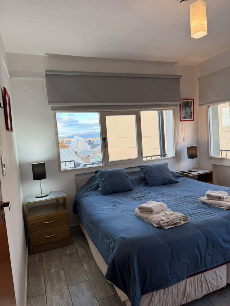 Una camera da letto con un letto, due comodini, una finestra con vista e una lampada a soffitto.