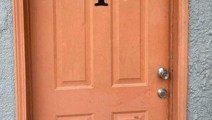 A wooden door with the number 1, a metal handle, and a keyhole. - Menta Condo (San Felipe)