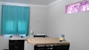 A small kitchen with a sink, a coffee maker, and a table. - Menta Condo (San Felipe)