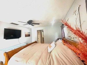 Cozy retreat with a single bed, ceiling fan, and flat-screen TV.