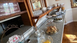 Um balcão de pequeno-almoço com teto de madeira, espelho e diversas opções para o pequeno-almoço.