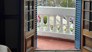 Uma varanda com vista para a rua e edifícios.