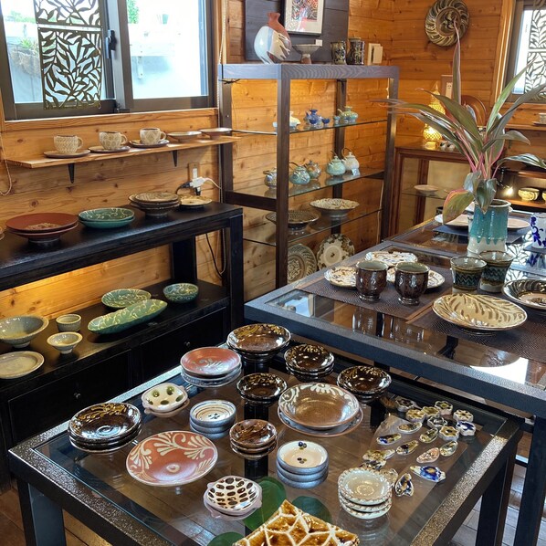A display of various ceramic dishes and bowls on shelves and tables.