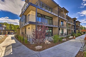 Stunning multi-story building with a contemporary design, set amidst a beautifully landscaped yard with a variety of plants.