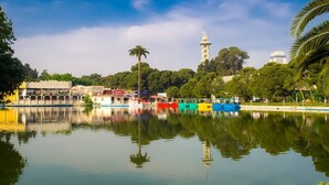 A calm lake with boats, a mosque, and lush greenery. - Maxxmarine hotel (Izmir)