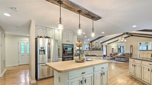A spacious kitchen with a central island, stainless steel appliances, and pendant lighting. - Charles Town Home w/ Private Pool & Hot Tub (Charles Town)