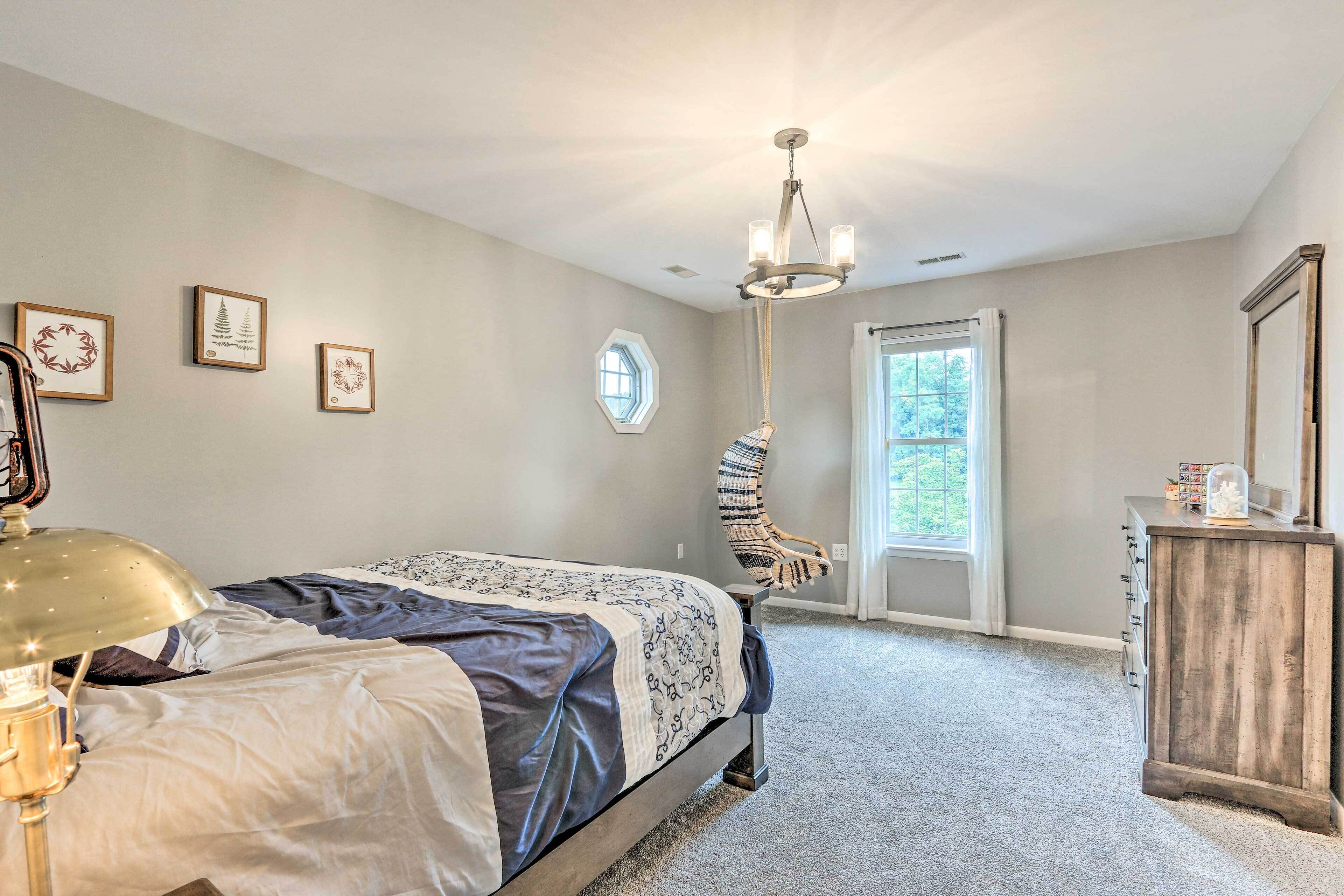 Une chambre à coucher avec un lit, un bureau, une chaise et une fenêtre.