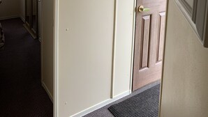 A hallway with a wooden door, a heart-shaped sign saying "Home Sweet Home," and a thermostat on the wall. - Remarkable 2-Bed Caravan  in Ingoldmells (Ingoldmells)