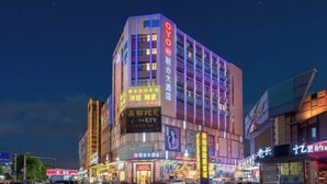 A multi-story hotel with illuminated signage, a prominent 'OYO' logo, and various commercial establishments on the ground floor. - Zhongshan Union Hotel (Zhongshan)