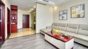 A modern living room with a sofa, a coffee table, and artwork on the wall. - Zhongshan Union Hotel (Zhongshan)
