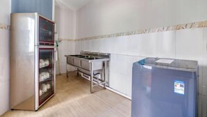 A kitchen with a stainless steel refrigerator, a glass-fronted cabinet, and a sink. - Zhongshan Union Hotel (Zhongshan)