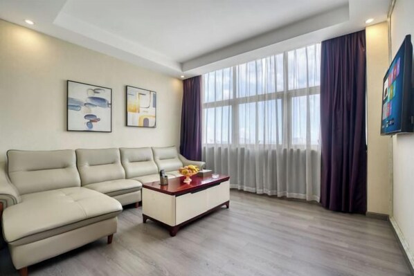 Ein modernes Wohnzimmer mit einem beigen Sofa, einem Holztisch und zwei gerahmten Kunstwerken.