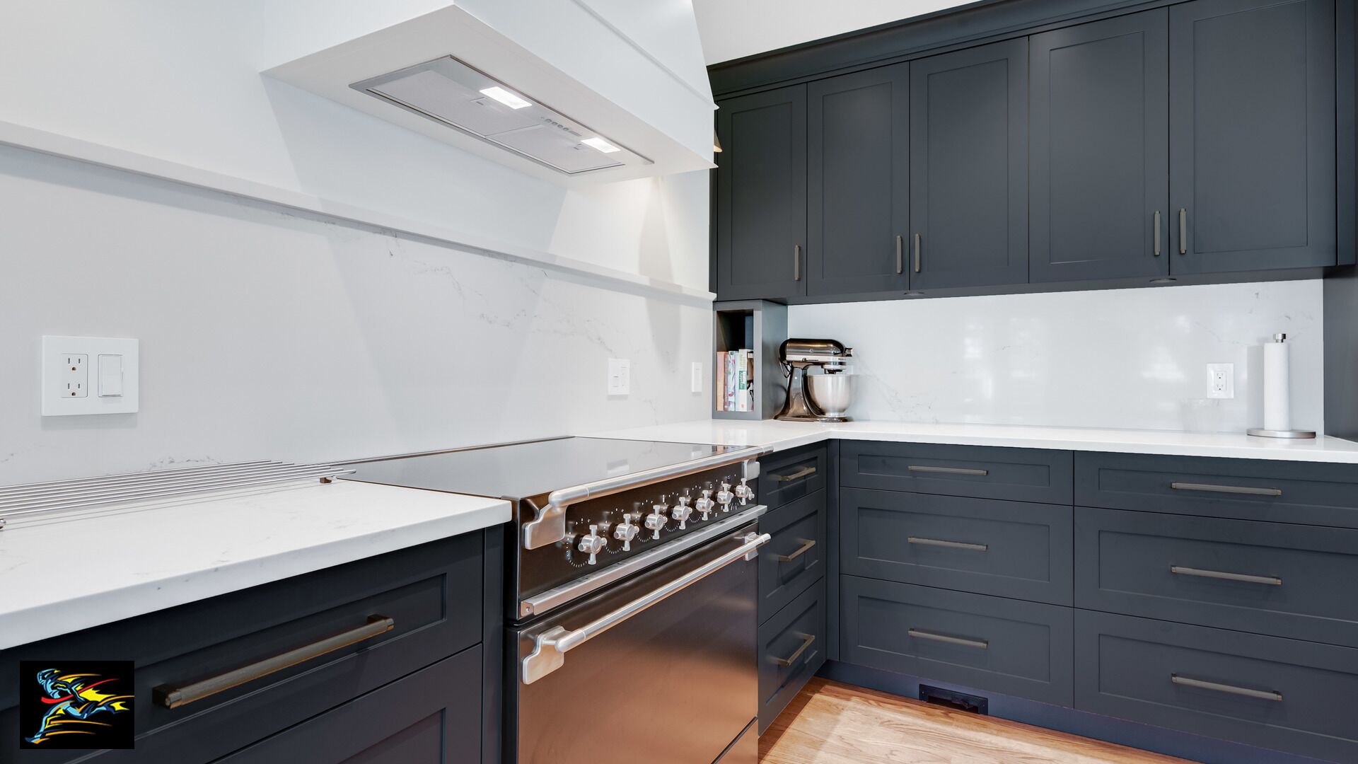 Une cuisine moderne avec des meubles de couleur sombre, une cuisinière en acier inoxydable et un plan de travail blanc.