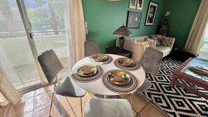 A dining area with a round table, chairs, and a patterned rug. - Walk Downtown, 2 Large Mountain View Patios (Palm Springs)