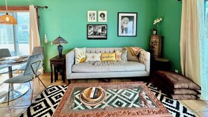 A living room with a sofa, a patterned rug, and a dining area with chairs and a table. - Walk Downtown, 2 Large Mountain View Patios (Palm Springs)