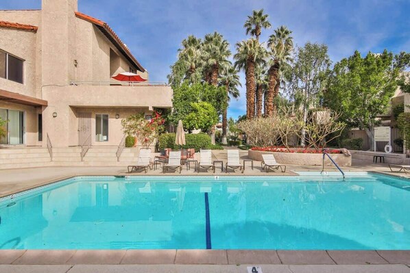 A swimming pool with lounge chairs, palm trees, and a building with a red roof. - Walk Downtown, 2 Large Mountain View Patios (Palm Springs)