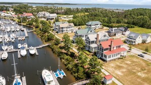 A marina with multiple boats docked, surrounded by residential buildings with varied architectural styles.