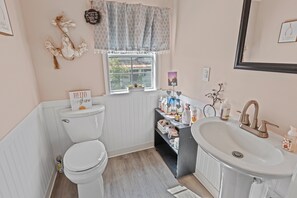 Ein Badezimmer mit Toilette, Waschbecken und Fenster.